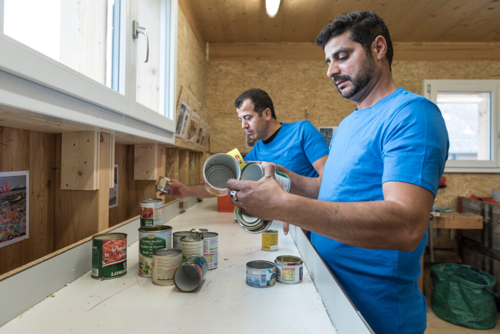 Zwei Mitarbeiter des Läbesruums sortieren Aludosen für das Recyclingabo.