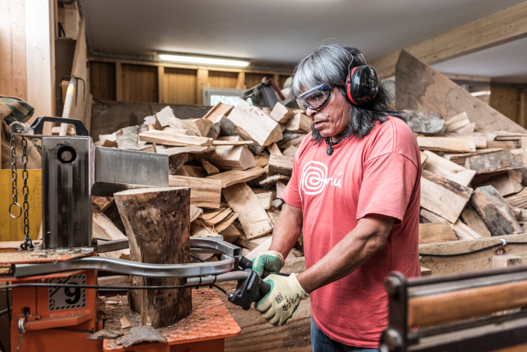 Ein Mitarbeiter des Läbesruums spaltet Brennholz.
