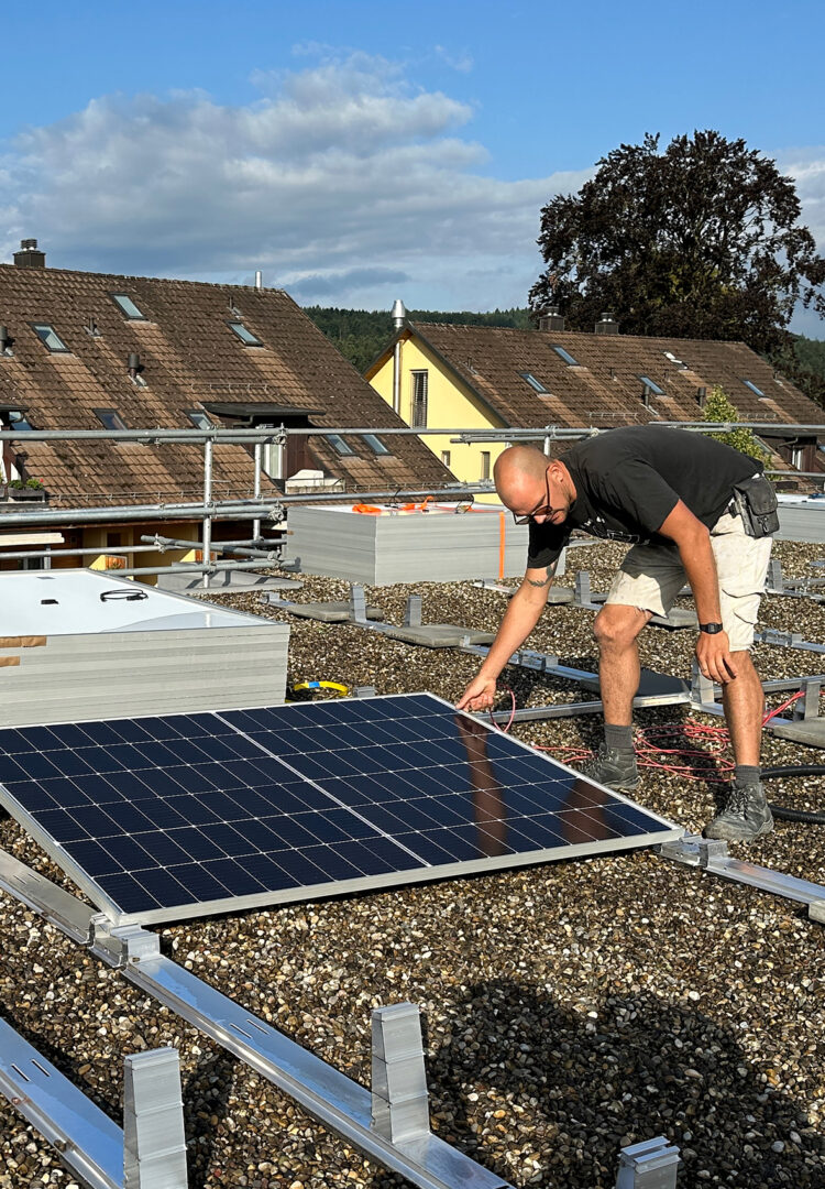 Ein Mitarbeiter des Läbesruums montiert eine Solaranlage.