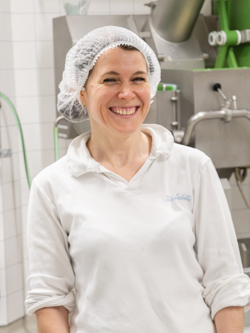 Eine Mitarbeiterin des Läbesruums lachend in der Küche.